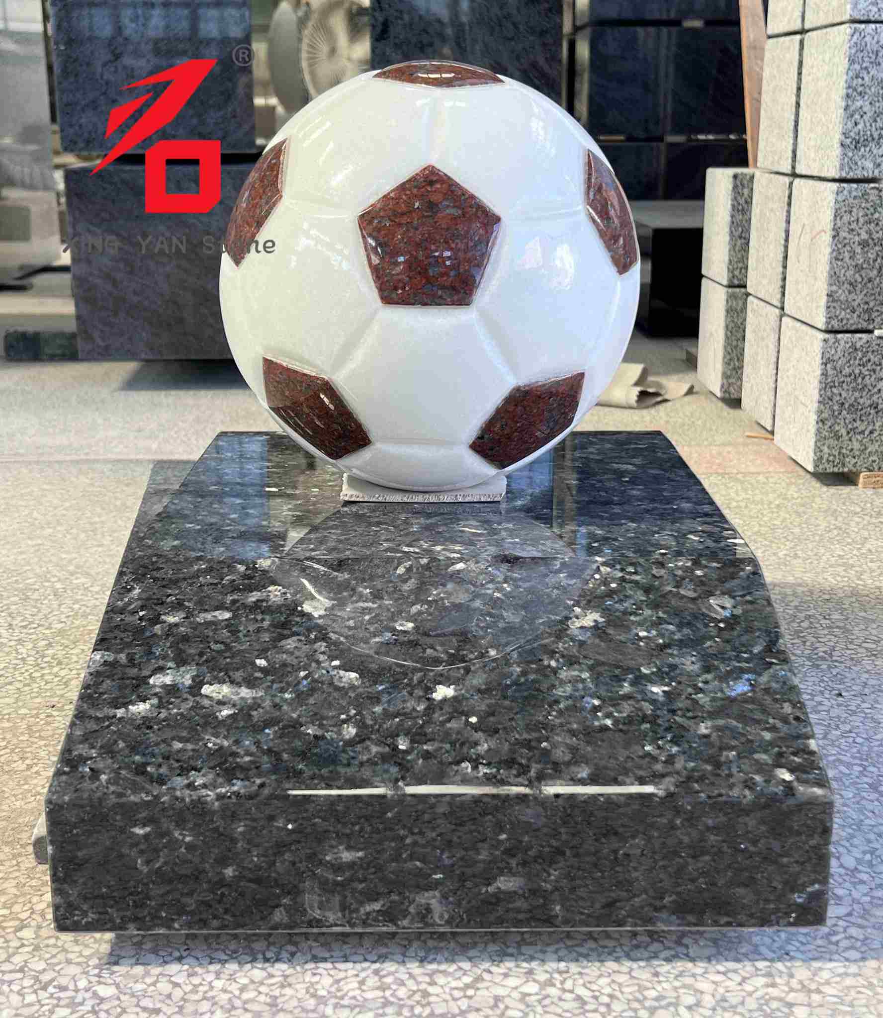 Escultura artística em granito em formato de bola de futebol